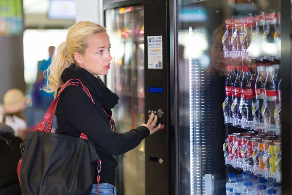 Femme utilisant un distributeur automatique